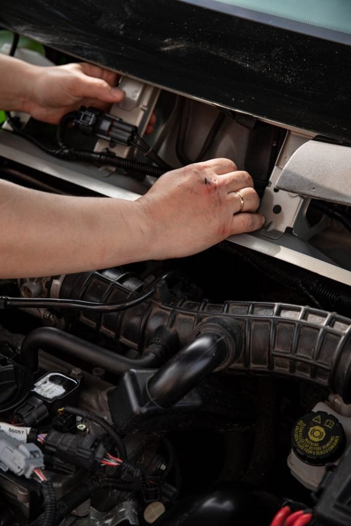 Close-up of a mechanic fixing car engine parts, showcasing hands-on expertise in repair.